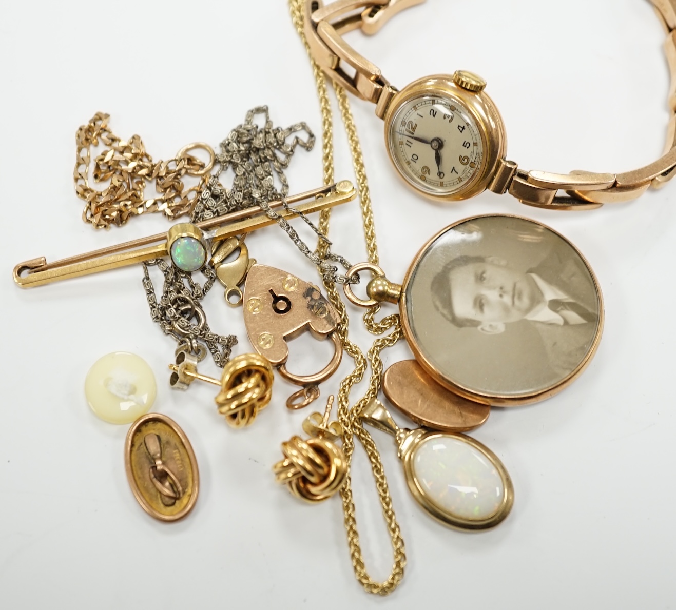 A lady's yellow metal manual wind wrist watch, on a 9ct expanding bracelet, a modern 9ct gold and white opal set pendant, on a 375 chain and other minor jewellery including a pair of 9ct gold knot earrings.